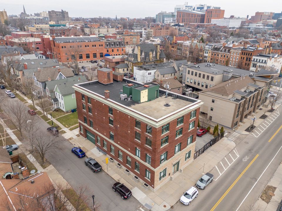 Aerial view of 430 Virginia Street on its corner, surrounded by Allentown's tree-lined streets, with the Buffalo Niagara Medical Campus on the horizon