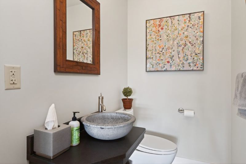 Bath with a stone vessel sink on a dark vanity
