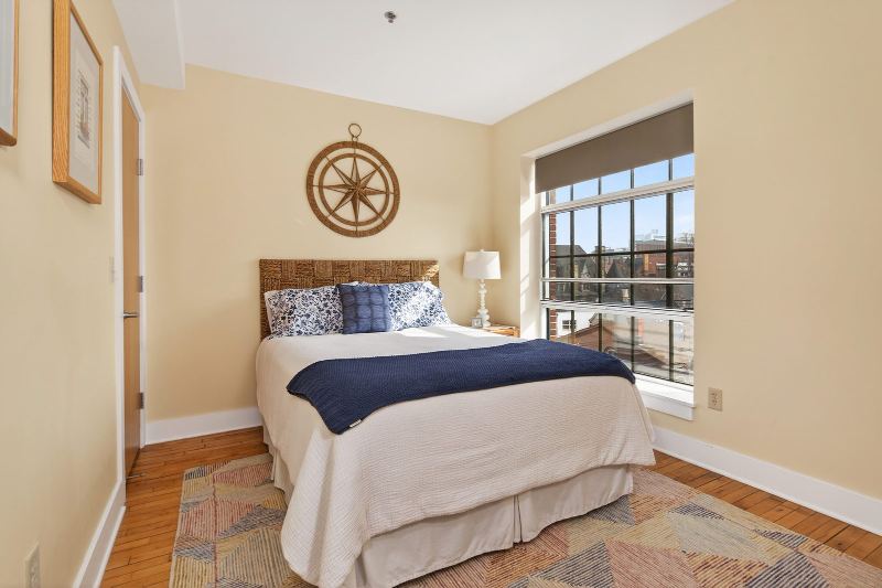 Bedroom with original hardwood floor and a large multi-pane factory window