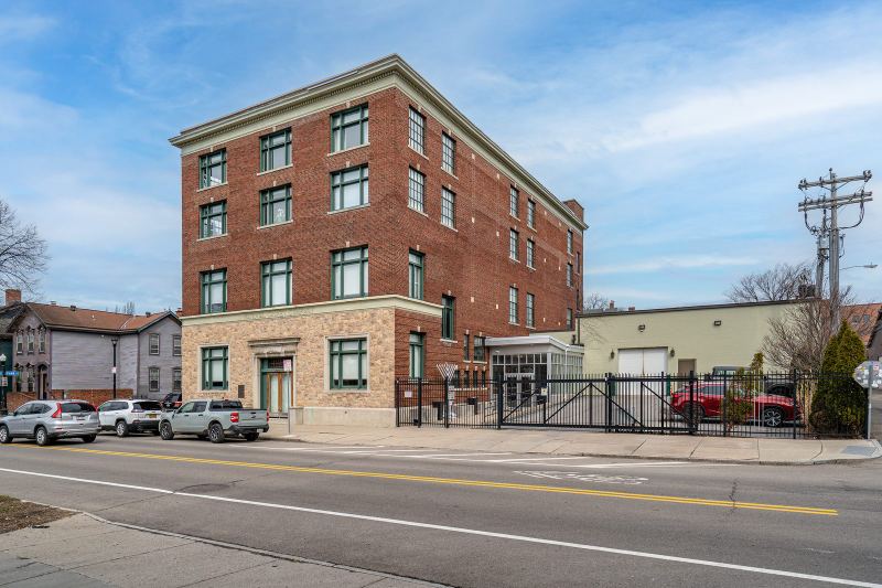 The building's brick façade and gated off-street parking on Virginia Street